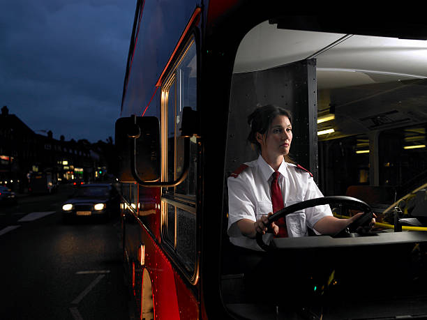 female bus driver on the road in urban environment with car overtaking. For educational purposes only